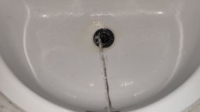 Old man with small limp cock pissing in the sink.