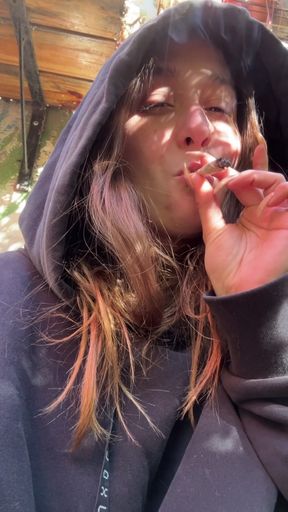 Smoking woman enjoys some outdoor fun in a wetsuit