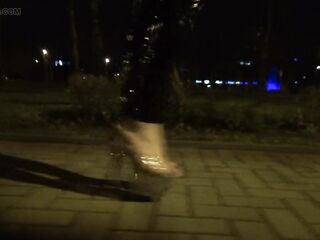 crossdresser walks on the street in transparent high heels