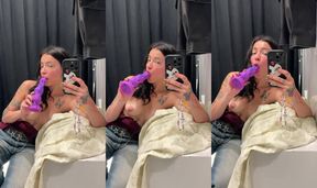 Tattooed brunette teasing with a purple dildo in the mirror at the shop
