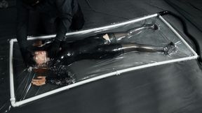 Sonya in a little black dress in a vacuum bed plays with her breath