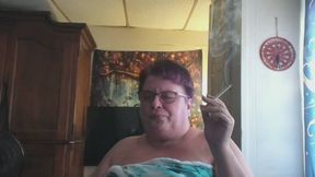 Mature lady, fresh out of the shower, no makeup, eyeglases, smoking a cigarette listening to radio