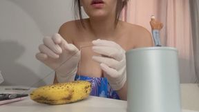 Giantess stepsister in white medical gloves operates on a banana and tiny stepbrother her assistant helps her operate and sew the banana together with thread