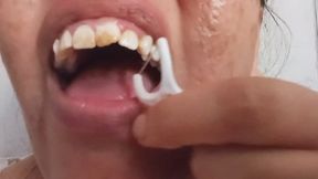 Cleaning yellow teeth with dental floss