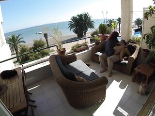 Sexo sigiloso en balcon de playa mientras pasea la gente cerca