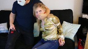 Dresden wearing a shiny golden blouse and jeans is a cowgirl held for ransom, cleave gagged and then ballgagged