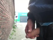 Boy piss outdoors while cars driving by