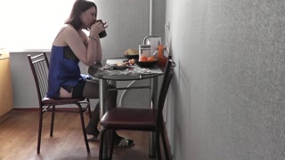 Beautiful sexy cute girl student in erotic lingerie peignoir stockings in kitchen preparing coffee