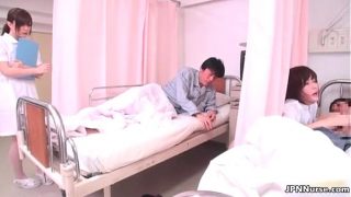 Geile Japanse verpleegster cosplayer zuigt aan de penis van een patiënt terwijl ze door een ander met de vingers wordt bevredigd.