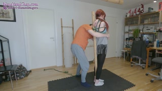 Girl tied hanging under bamboo pole
