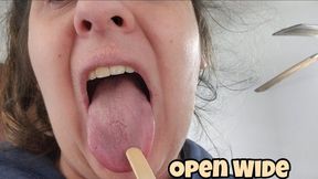 Medical tongue exam with wooden stick close-up inspection, opening mouth wide and showing tongue movements