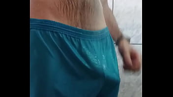 Man takes a shower and shows off his bulge volume in his shorts