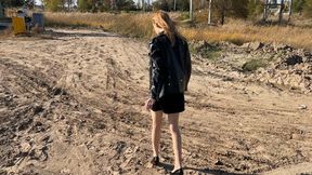 girl in stockings and high-heeled shoes walks through the mud and slides on it, dirtying her stockings