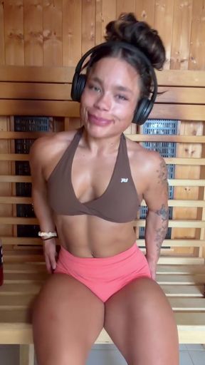 Female bodybuilder in sports bra and headphones