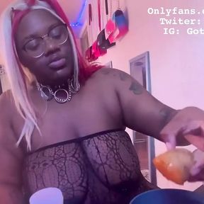 Ebony BBW stuffs her face while she is topless