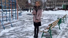 a girl plays on a summer playground in winter at -15 barefoot in stockings and a dress (reupload)