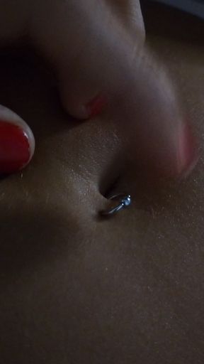 Close-up of a person's belly button with a piercing