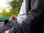 A guy in public pisses and jerks off his cock on the river bank, and a fisherman is fishing nearby