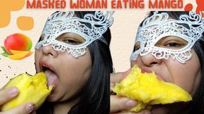 Masked woman eating mango