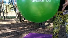 girl play on yogaball in forest