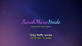 Big girl feet with grey fluffy socks