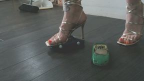 Giantess goddess Charlie Caroline Crushes a 2 Chevrolet Corvette's in gold strappy heels with painted toenails low close right view