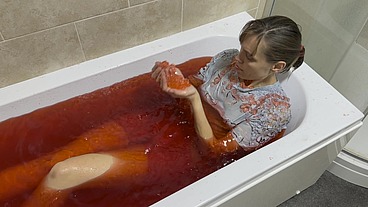 A bath in red coloured Jelly Cubes. As I scoop up the jelly cubes into a sieve, and empty them back over my body