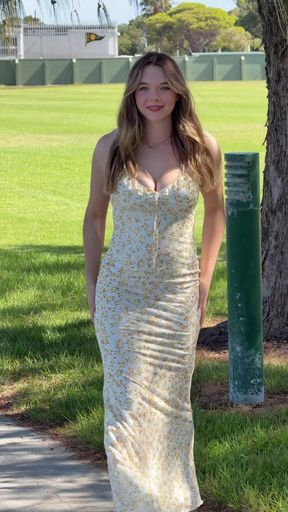 Blonde woman in strapless dress walking on sidewalk