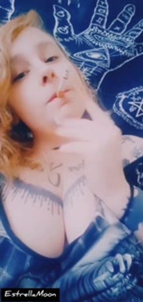 redhead girl plays with her tits and smokes a cigarette