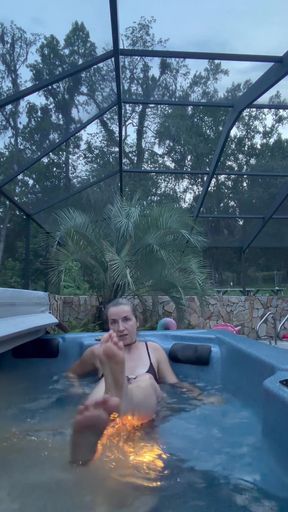 Woman in pool with foot on man's face