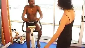 Brunette gets it on with a friend's big black cock while riding his bike