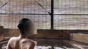 japanese girl bathing in a mixed outdoor bath at a hot spring inn
