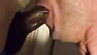 Amateur sucks big black cock at glory hole