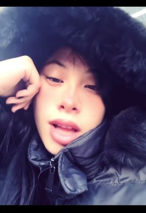 Woman in fur coat sitting outdoors