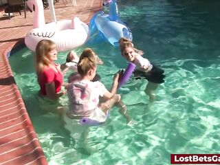 Four slender ladies in the pool along with their hunk ally