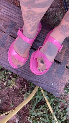 Black pedicure and pink sandals in nylons