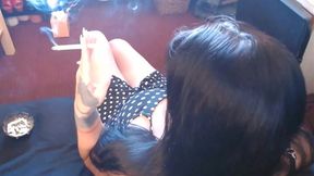 Black-haired MILF smokes and shows cleavage while ignoring the voyeur cam