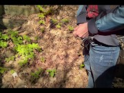 Bearded guy pissing in the forest. A man relieves himself in nature