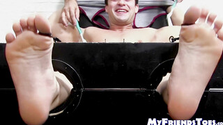 Restrained hunk laughs while tickle tormented by his dom