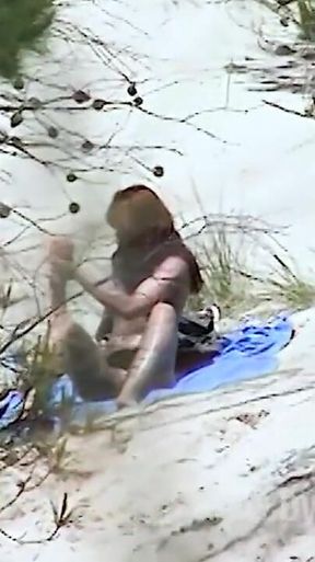 Redhead beauty dildoing pussy on the sandy beach