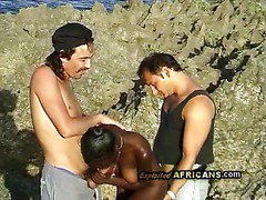 Horny black babe sucks off 2 big white rods at the beach