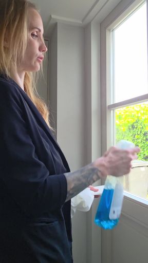 Woman cleaning window in bathroom
