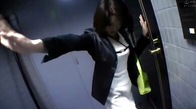 Businesswoman in blazer meets her lover in a dim office hallway before retreating to the bedroom