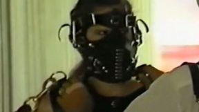 White chick in heavy black leather BDSM outfit restrained on the farm