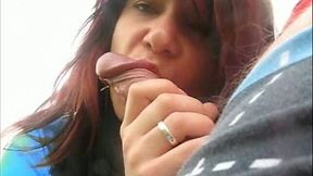 Shameless redhead is quite into sucking cock outdoors near the car