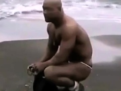 Asian bodybuilder barely covered at the beach