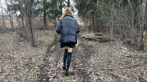 a slender long-legged girl walks in high boots with high heels through puddles and mud, gets stuck in the mud, her boots fill with water