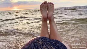 Beautiful Wrinkled Soles and Toes Wiggling Against the Backdrop of a Sunset on the Sea Beach