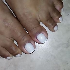 Closeup on Morenafeet&#039;s fingers with French nail polish