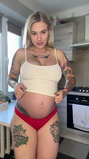 Busty pregnant woman flaunts her big tits and growing belly